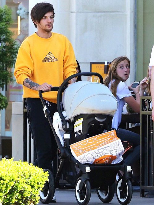 ZOMG that IS Louis Tomlinson of One Direction pushing his kid Freddie or whatever in a Bugaboo Buffalo stroller with a Maxi-Cosi Mico Infant Carrier and appropriate adapters, each sold separately, how ever did this picture happen, what with his body guard on one side and his posse member/paid friend on the other, the mind reels but the pap experts at x-online know how these things are done.